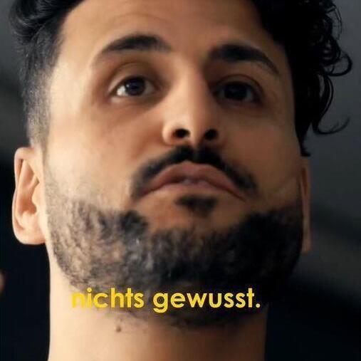 You can see a man and in front of him there is the line nichts gewusst which translates to not known.